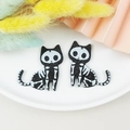 Macro shot of Halloween black acrylic skeleton cat pendants with glitter finish details - Cat