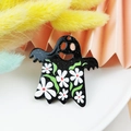 Detail of ghost charm accessory with white daisy patterns on black acrylic surface - Black Ghost with White Flowers (4)