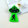 Close-up of fluorescent green acrylic UFO pendant with bigfoot silhouette for DIY jewelry - Green