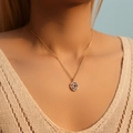 18K gold plated flower necklace featuring multi-colored zircon heart pendant on model - Multicolor Heart Hollow Circle (KN0363-1)