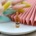 Detailed view of orange resin miniature liquor bottle pendant for DIY jewelry crafts - Brown