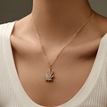 Gold plated maple leaf necklace with sparkling crystals shown on female neck - Pave Leaf Style (KN0335)