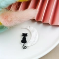 Detalle de los dijes de acrílico de luna y gato negro para crear joyas y accesorios DIY - Gato de Luna Izquierda
