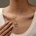 Gold plated necklace with hollow sun flower and palm tree pendant on a model - Sun Ring Coconut Tree Style (KN0336)