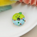 Macro view of colorful resin donut pendant with cute eyes and rainbow sprinkles - Green Blue Monster Donut