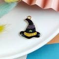Detail of an enamel witch hat pendant with Good Witch text and a green star charm - Star Magic Hat