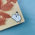 Detailed view of white enamel ghost pendant with black drip oil for Halloween jewelry - Black and White