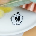 Macro-detail van een Halloween schedel emaille bedeltje met zwarte olie-druppel afwerking - Hechte Schedel (4)