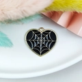 Macro shot of Halloween heart pendant with black enamel finish and gold spider web detail - Black