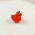 Glinsterende rode hars eend hanger met metalen ring op witte getextureerde achtergrond - Rood