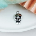Macro view of a silver skull pendant with black enamel details and fixed hanging loop - Silver 3D Skull Head (5245276602931)