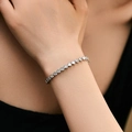 Minimalist white gold tennis bracelet with round cubic zirconia on model's wrist - Round Prong Set Style (KB0540) / 18K Gold