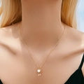 Detail of gold cat pendant necklace with white pearl and rhinestones on a delicate chain - Cat Pearl Necklace (KN0423)