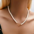 Detailopname van parelketting met een gouden OT-sluiting bij een vrouwelijk model - Gouden OT Gesp Parel Sleutelbeenketing (KN0432)