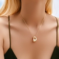 Classic gold plated necklace featuring an organic bean shaped pendant on a delicate chain - Letter D Style (KN0464-D)