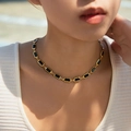 Elegante gouden ketting met vierkante zwarte glasstenen gedragen door een model - Zwarte Agaat Rechthoek Schakel (KN0578-1)
