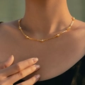 Elegante 18K vergoldete Halskette mit Herzgliedern und weißen Perlen an einem Frauenhals - Perle Herz Verbindung (KN0567)