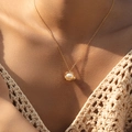 Elegant 18K gold plated copper necklace featuring a white pearl pendant on model - Lava Texture Pearl Necklace (KN0517)