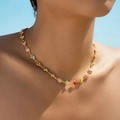 Gouden ketting met gekleurde hartvormige edelstenen gedragen onder een blauwe lucht - Kleurrijke Klauw Hart (KN0572)
