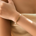 Dettaglio del bracciale a catena dorata con perle irregolari sul polso di una donna - Stile Catena a Maglie con Tre Perle (KB0747)