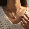 Gold sunflower necklace with red gemstone inlay pendant worn by a female model - Red Stone Radiating Style (SN0022-2)