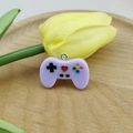 Close-up of purple resin game controller charm with colorful buttons and heart detail - Lavender