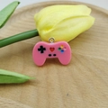 Detail of a pink resin game controller pendant charm with a silver metal hanging loop - Rose Red