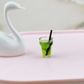 Détail macro d'une tasse miniature de boisson au citron avec paille pour maison de poupée - Vert