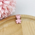 Close-up of a pink matte teddy bear DIY pendant on a wooden tray with flowers - Pink Bear