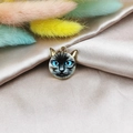Gros plan d'un pendentif chat siamois émaillé avec bordure dorée sur soie et fleurs séchées - Chat Siamois aux Yeux Bleus (1)