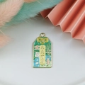Green omamori enamel pendant charm with golden accents and inspirational text - Bright Future
