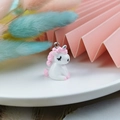 Detailed view of 3D resin unicorn pendant charm with pink feathers background - Pink