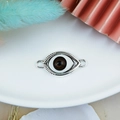 Detailed macro view of silver evil eye connector charm for handmade jewelry making - Brown