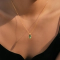 Detailed close-up of bohemian gold shell pendant necklace on female collarbone - Oval Rainbow Green Style (KN0601-1)