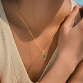 Detail of bohemian gold crescent moon pendant with green inlay worn on model - Crescent Moon Star Style (KN0601-7)