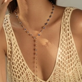 Détail du collier lasso doré avec cœurs bleus porté sur un haut au crochet bohème - KN0652-3 (Collier Y Cœur Bleu) / Or 18 carats