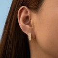 Pendientes rectangulares dorados con microcirconitas lucidos por una modelo femenina - Fila Rectangular de Circonia (KE1721)
