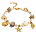 Bracelet style marin plaqué or 18K avec pendentifs coquillages et étoiles de mer sur fond blanc - Bracelet DIY Créatures Marines - Or