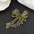 Vintage gold bow brooch with blue rhinestones on black and white satin background - Blue Rhinestone Bowknot (Vintage Bowknot Brooch - Blue Diamond) / Blue