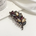 Dettaglio della spilla vintage a foglia con cristalli viola e champagne su seta - Viola