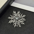 Dettaglio ravvicinato di una spilla a fiocco di neve argentata con perla grigia centrale - Argento (Perla Grigia)