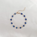 Dettaglio del bracciale Evil Eye dorato con ciondoli in smalto blu e chiusura regolabile - Blu Scuro KC Oro