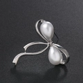 Elegante spilla a fiocco con perle a goccia e strass su uno sfondo nero intenso - Bianco