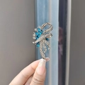 Dettaglio macro di una spilla a fiocco con pietre blu marquise e strass bianchi lucidi - Blu