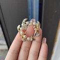Elegante gouden bloemenkrans broche met parels en zirkoonstenen in de hand gehouden - Krans blad parel broche