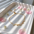 Elegante gouden hartarmband met parelschelpen en fonkelende kristallen op een plateau - Hart Schelp / Goud