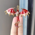 Spilla drago dorata elegante con ali in smalto rosso e cristalli tenuta tra le dita - Rosso