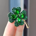 Close-up of four-leaf clover brooch with green rhinestones and golden metal detail - Green Large (XZ0190)