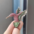 Dettaglio di una spilla a colibrì vintage con strass rosa e verdi scintillanti - Rosa Base Argento
