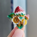 Primer plano del broche de fresa en esmalte con flores y cristales en la mano - XZ0228-1 Fresa Floral